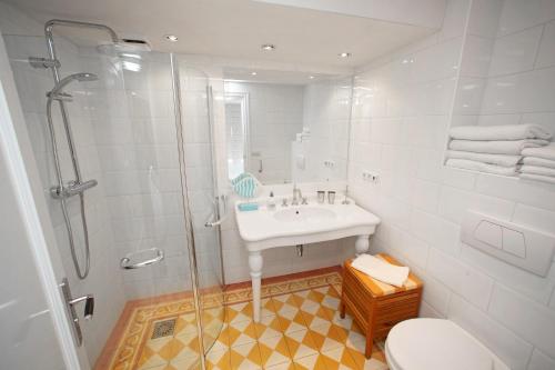 a white bathroom with a shower and a sink at Aan Zee en Duin in Egmond aan Zee