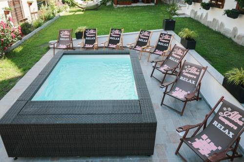 una piscina con sillas, una mesa y una piscina en Alba Camere Chiomonte, en Chiomonte