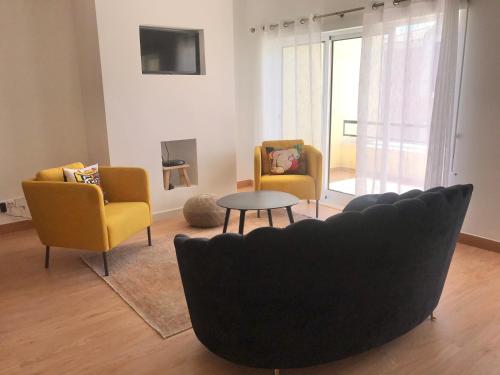 a living room with two chairs and a couch and a table at Casa do Sol in Sesimbra