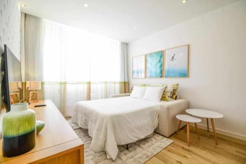 a bedroom with a bed and a couch in it at Timeless Beach II Apartment in Armação de Pêra