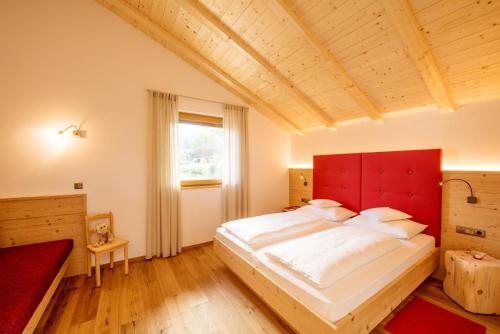 1 dormitorio con 1 cama grande y cabecero rojo en Haus Sonnegg Familiensuite, en Laion