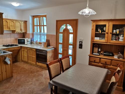 a kitchen with a table and a dining room at Éva Apartmanház 2 in Csopak