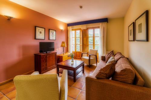 a living room with a couch and a tv at Jardines de La Santa in Totana