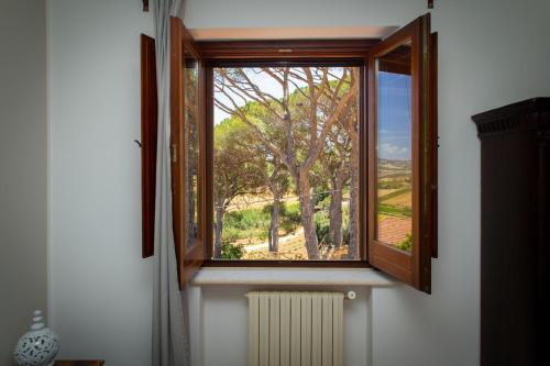 a window with a view of a tree at Feudo Giglio Country Charme in Calatafimi