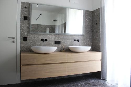 a bathroom with two sinks and a mirror at Schubert am Wörthersee in Krumpendorf am Wörthersee