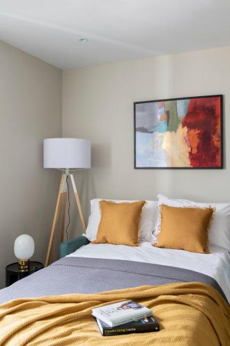 a bedroom with a bed with a painting on the wall at COVE Cannon Street in London