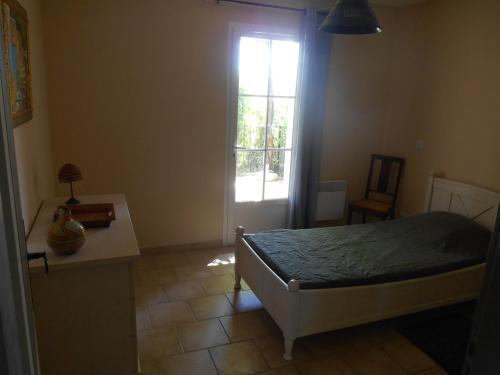 une chambre avec un lit et une fenêtre dans l'établissement Le Cabanon d'Amandine et Gabriel, à Blauvac