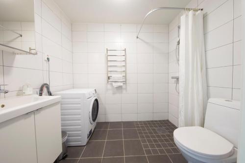 a white bathroom with a toilet and a sink at Continental Apartment Hotel Sollentuna in Sollentuna