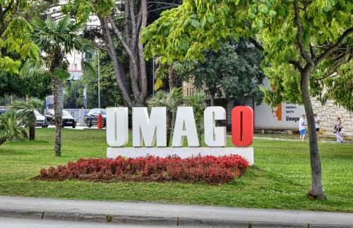 a large sign in a park with trees and flowers at Rocca Riviera Umag Luxury Apartments in Umag