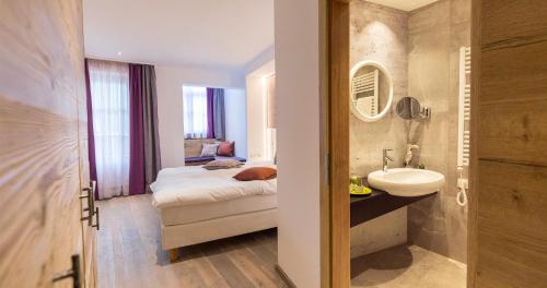 łazienka z łóżkiem i umywalką w pokoju w obiekcie Hotel Flachauerhof w mieście Flachau