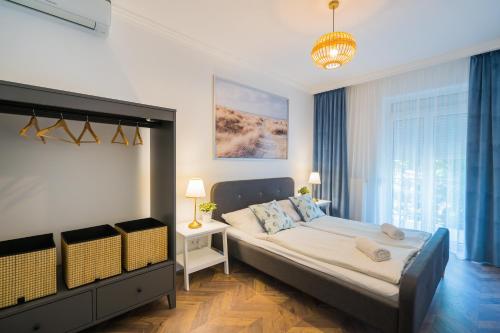 Un dormitorio con una cama grande y una lámpara de araña. en Csenge Villa, en Siófok
