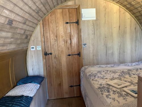 een kleine kamer met 2 bedden en een deur bij Romantic escape luxury Hobbit house with Hot tub! in Sheerness