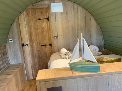 um pequeno quarto com uma cama e um veleiro num balcão em Romantic escape luxury hobbit house with hot tub em Sheerness