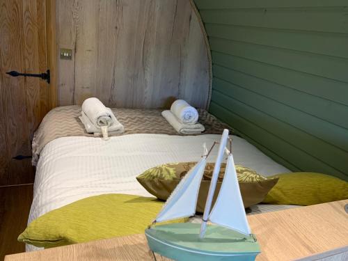 a bedroom with a bed with a toy sailboat on it at Romantic escape luxury hobbit house with hot tub in Sheerness