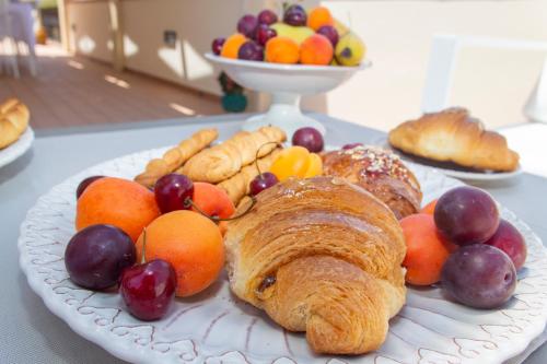 a plate of pastries and fruit on a table at Feudo Giglio Country Charme in Calatafimi