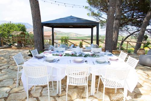 a white table with white chairs and a gazebo at Feudo Giglio Country Charme in Calatafimi