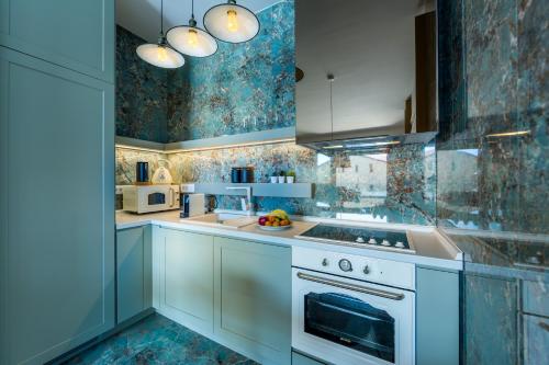 a kitchen with white cabinets and a stove top oven at Rocca Riviera Umag Luxury Apartments in Umag
