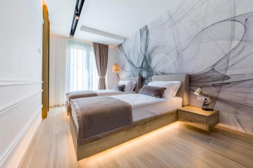 a hotel room with two beds and a mural at Rocca Riviera Umag Luxury Apartments in Umag