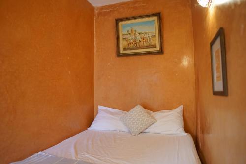 a bed in a room with a picture on the wall at Riad Dama & Spa in Marrakech