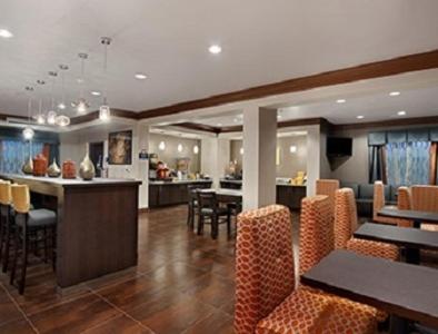 a restaurant with tables and chairs and a bar at Days Inn by Wyndham Dilley in Dilley