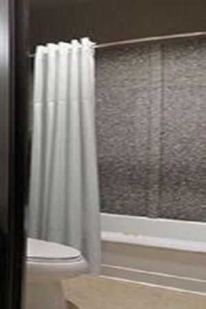 a bathroom with a shower curtain and a toilet at Days Inn by Wyndham Dilley in Dilley