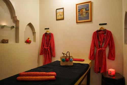 a table with red clothing hanging on a wall at Riad Dama & Spa in Marrakech