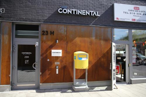 a building with a yellow trashcan in front of it at Continental Apartment Hotel Sollentuna in Sollentuna