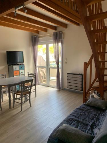 un salon avec une table et une salle à manger dans l'établissement Duplex proche mer, à La Rochelle
