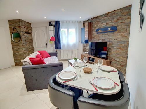 a dining room with a table and a couch at Stop Chez M Select Street # Qualité # Confort # Simplicité in Saint-Fons