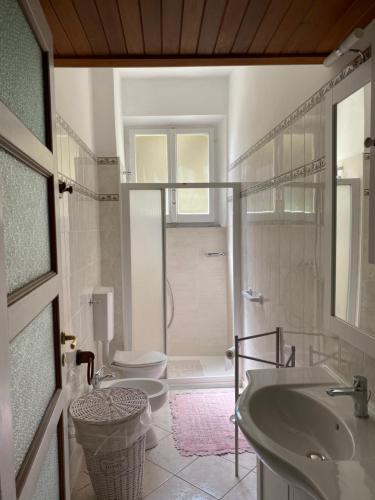 een badkamer met een wastafel, een toilet en een douche bij Là Mì Cà in La Spezia