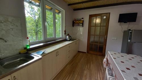 a large kitchen with a sink and a window at DILI Cottage in Dilijan