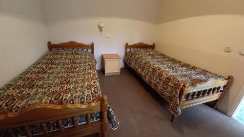 two beds sitting next to each other in a room at DILI Cottage in Dilijan