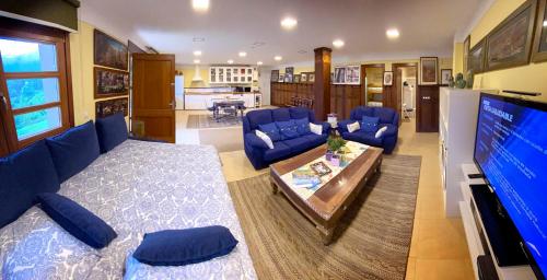 un soggiorno con divani blu e una grande TV di Loft 80 mts en un entorno natural. a Mieres