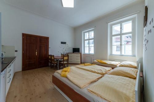 ein Schlafzimmer mit 2 Betten und eine Küche mit einem Tisch in der Unterkunft Vratislavsky Dum in Třeboň