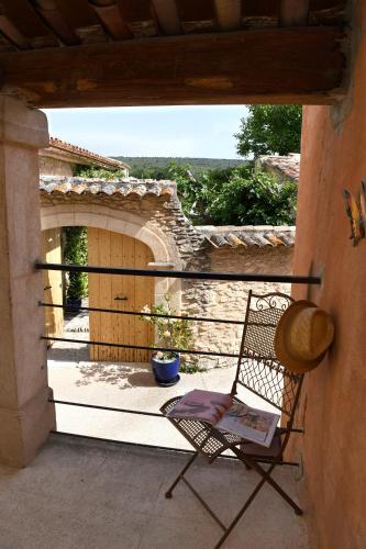 a chair sitting on the porch of a house at Gîte des Demoiselles en Luberon in Roussillon