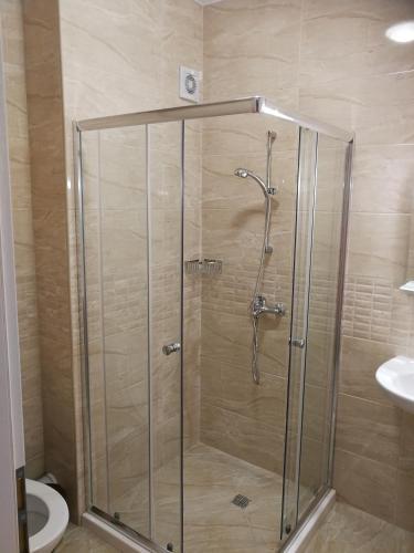 a shower stall in a bathroom with a toilet at Donchevi Apartments in Primorsko