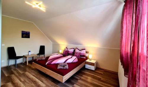 1 dormitorio con 1 cama con almohadas rosas en Nap-Hold Apartman en Keszthely