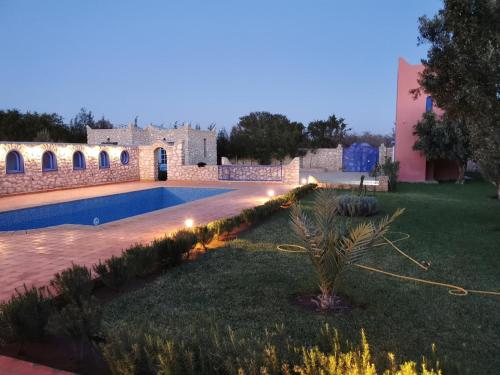 einen Hinterhof mit einem Pool und einem Gebäude in der Unterkunft Dar Yanis in Essaouira