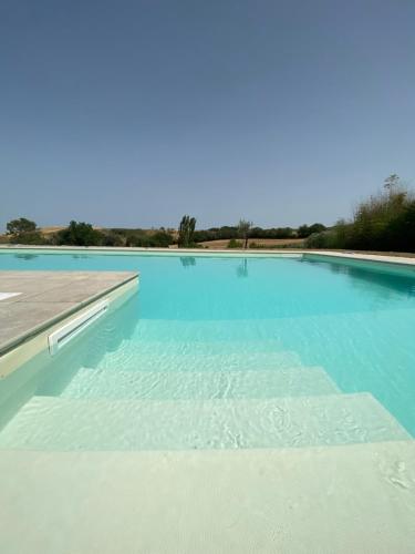 a large swimming pool with blue water at Villa Rina in Pesaro