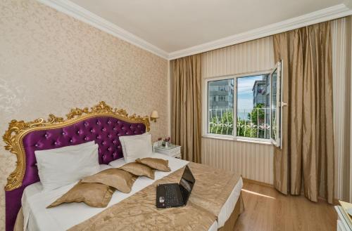 a bedroom with a bed with a laptop on it at Santa Sophia Hotel - İstanbul in Istanbul