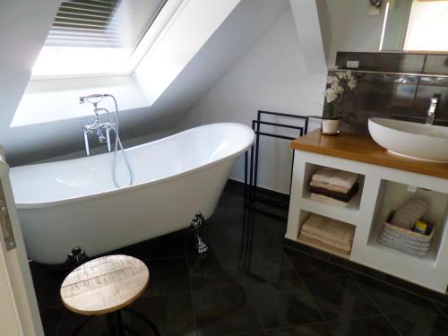 a bathroom with a white tub and a sink at Elbflair in Zahna-Elster