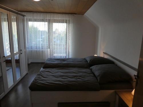 a bed in a room with a large window at Haus am Park in Rommerskirchen