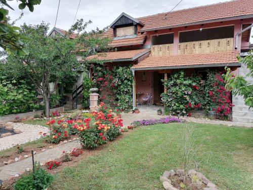 a house with flowers in front of a yard at Apartman Mika in Soko Banja