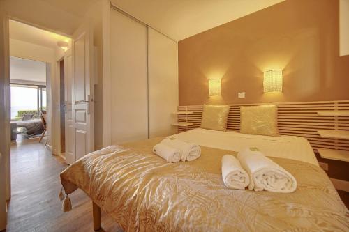 une chambre avec un lit avec des serviettes dessus dans l'établissement IMMOGROOM - sea view- Pool- Parking- garden, à Cannes