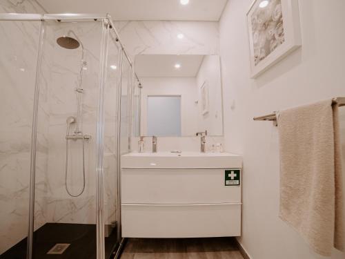 a bathroom with a sink and a shower at Casa do Coreto, Paço, São Bartolomeu dos Galegos in Paço