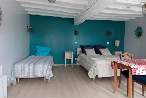 1 dormitorio con 2 camas y pared azul en Chambre d hôtes en Montjavoult