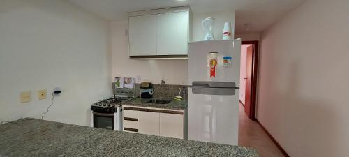 a kitchen with a refrigerator and a counter top at Aldeia St Sebastien 31 Arembepe in Arembepe