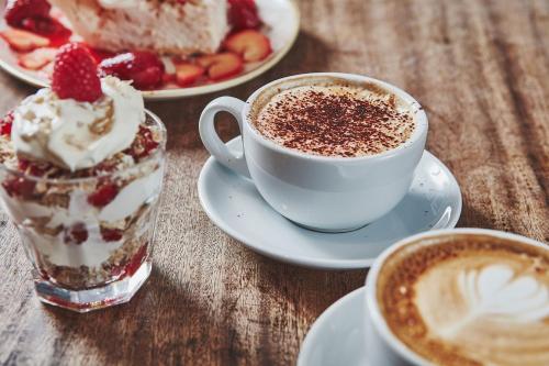 a table topped with two cups of coffee and desserts at Brambles of Inveraray in Inveraray