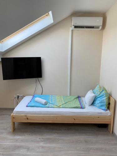 a bedroom with a bed with a tv on the wall at Kiskakas Étterem in Zalaegerszeg