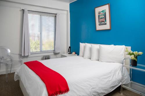 a bedroom with a white bed with a red blanket on it at Edwardian Hotel in San Francisco